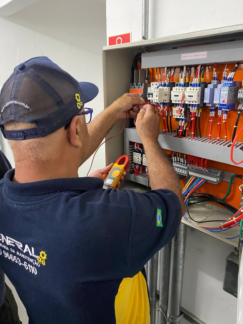 Técnico da General medindo corrente elétrica com alicate amperímetro dentro de um quadro de comando